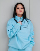 Close-up of “FLYYGIRL” logo on zip-up top